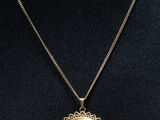 un collier en or avec un médaillon en pendentif sur un mannequin, un mannequin, un mannequin, un mannequin, un mannequin, un mannequin, un mannequin, un mannequin, un mannequin