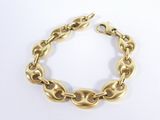 gros plan d'un bracelet en or sur une surface blanche