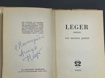 un livre ouvert, sur lequel figure un titre écrit à la main, posé sur une table