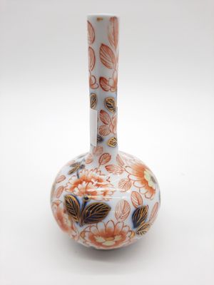 un vase blanc orné de fleurs orange et bleues