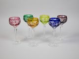 quatre verres à vin de couleurs différentes sont alignés en rangée