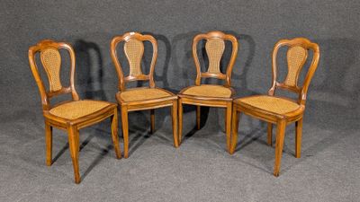quatre chaises en bois avec un dossier en rotin, sur fond gris