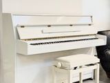 a white piano sitting in a living room next to a couch