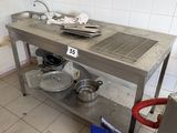 a kitchen with a metal table with pots and pans on it