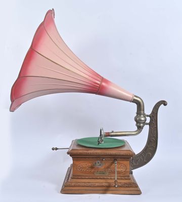 un gramophone rose et vert posé sur un socle en bois
