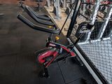 a gym area with a row of exercise bikes in it