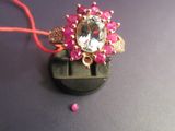 a pink bead and a gold ring on a black surface