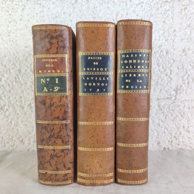 three old books sitting on top of a table next to each other