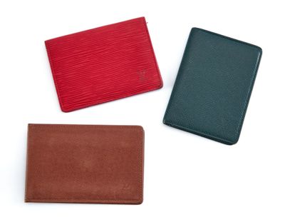trois portefeuilles en cuir de couleurs différentes sur fond blanc