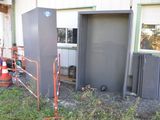 un petit bâtiment muni d'une porte métallique et d'une clôture métallique