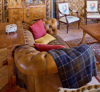 un salon avec un canapé, un fauteuil, une table et une commode