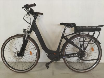 un vélo noir garé contre un mur blanc dans une pièce