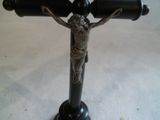 a statue of jesus on the cross holding two wine bottles