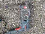 a corded drill sitting on the ground next to a corded cord