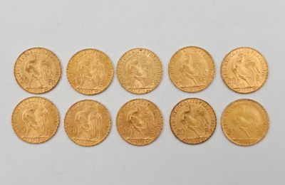 un gros plan sur plusieurs pièces d'or posées sur une surface blanche