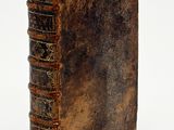 an old brown book sitting on top of a table next to a white background