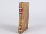 an old book sitting on top of a white surface
