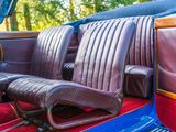 two seats in the back of a car with red carpet