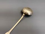 silver spoon with a spoon handle on a gray surface
