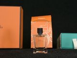 two bottles of perfume sitting next to each other on a table