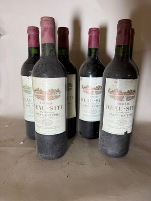 three bottles of red wine are lined up on a counter
