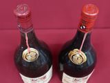 two bottles of liquor sitting on top of a red table