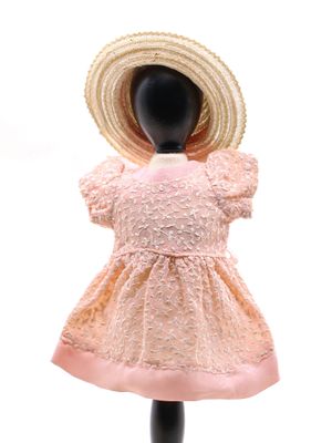 une robe rose et un chapeau sur un mannequin, sur fond blanc