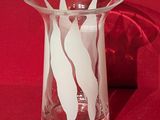 un vase en verre orné d'un motif blanc sur fond rouge