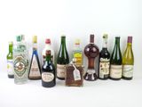 de nombreuses bouteilles d'alcool alignées sur une surface blanche