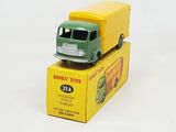 a green and yellow toy truck sitting on top of a yellow box