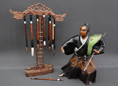 une figurine représentant un homme tenant une épée à côté d'un poteau