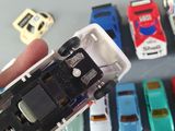 a person holding a toy car in front of a bunch of other toy cars