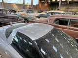 many old cars parked in a parking lot in a garage