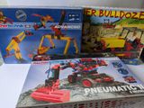 trois boîtes de legos de différents jeux de construction sur une table