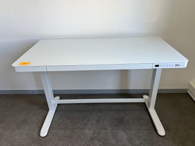 un bureau d'ordinateur blanc avec une étiquette jaune posée dessus