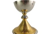 silver and gold chalicee with a cross on the base