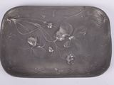 assiette en argent décorée de fleurs et de feuilles sur un fond blanc