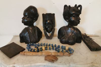 deux statues représentant des personnes assises sur une table avec un morceau de bois
