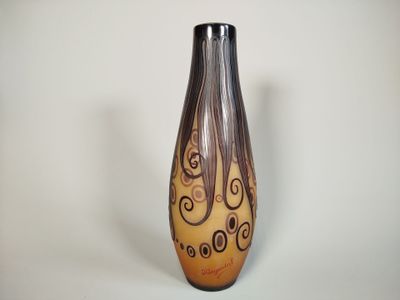a brown and black vase with swirl designs on it