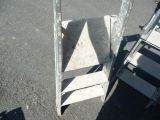 a ladder that is leaning against a wall in a parking lot