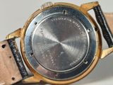 a close up of a watch on a white surface