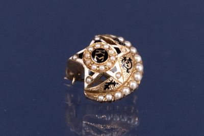 une image représentant une bague en or ornée de perles et d'une étoile