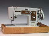 une machine à coudre posée sur un socle en bois