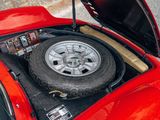 a red car with a flat tire in the trunk of it