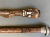 pair of wooden baseball bats with carvings on them on a table