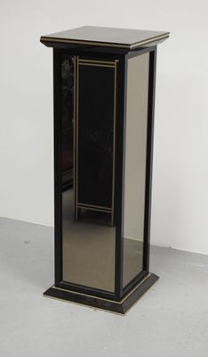 a small black cabinet with a mirror on it
