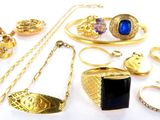 a lot of gold jewelry on a white surface