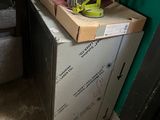 a small refrigerator in the corner of a room with a lot of stuff on it