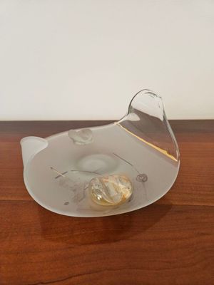 un bol en verre contenant une ampoule, posé sur une table en bois