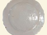 a white plate with a brown rim sitting on a table